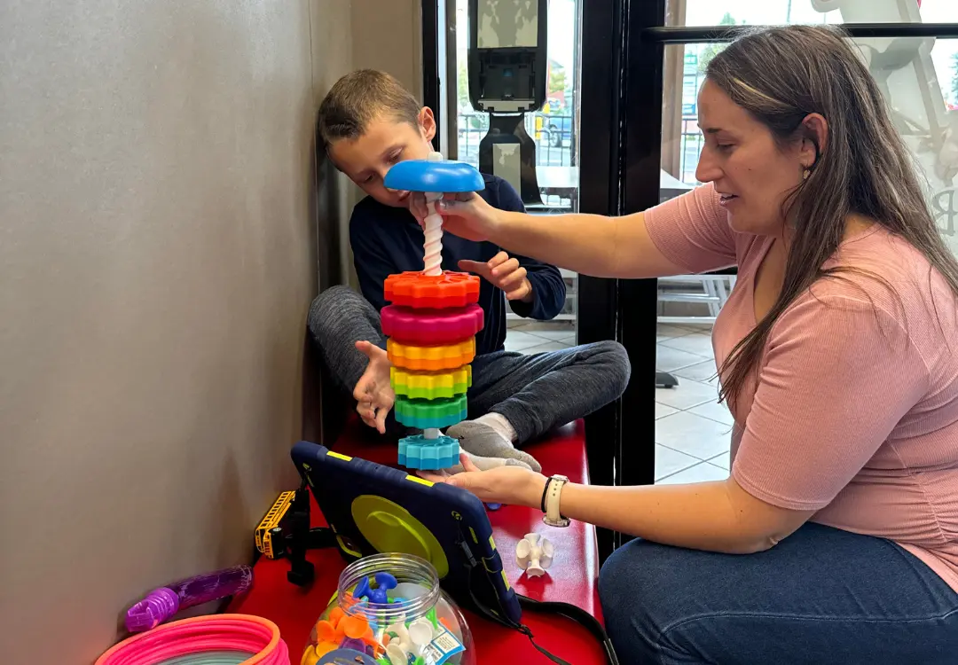 Katie, speech therapist, working with a child in the play center during a speech therapy session